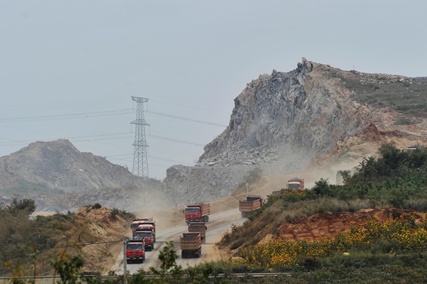 Trucks haul earth for a new island airport off the coast near Dalian, Liaoning province, on Sunday.[Photo by Liu Debin/China Daily] 