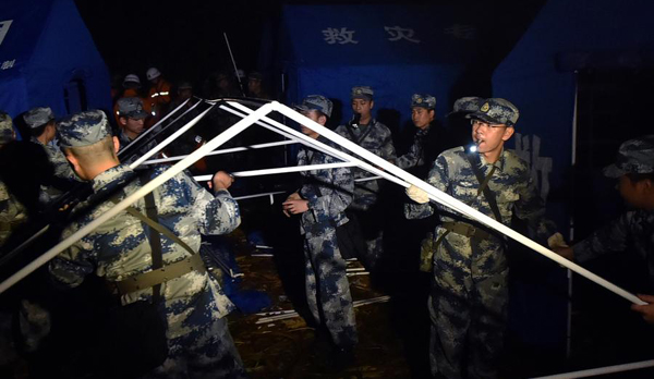 Rescuers set up tent for survivors after a 6.6-magnitude quake hit Jinggu county, Southwest China's Yunnan province, Sept 8, 2014. [Photo/Xinhua]