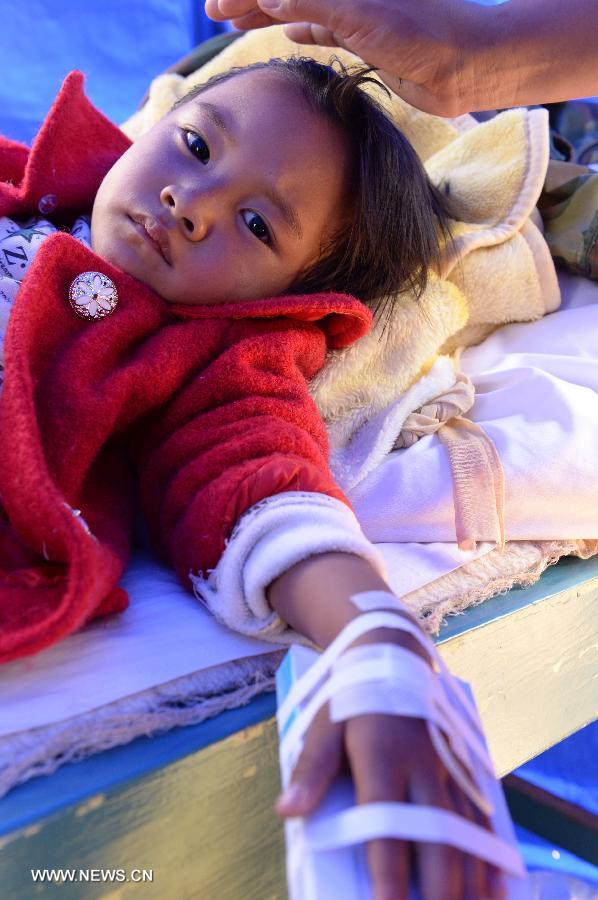 A girl receives medical treatment at a temporary medical center organized by the 2nd Renmin Hospital of Jinggu County, southwest China&apos;s Yunnan Province, Oct. 8, 2014. One person died and 324 others were injured after a 6.6-magnitude quake jolted Yunnan Province Tuesday night, according to local government. Injured villagers have been sent for medical treatment.