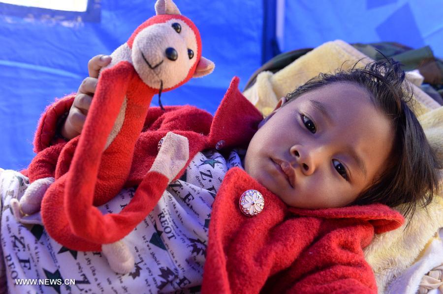 A girl receives medical treatment at a temporary medical center organized by the 2nd Renmin Hospital of Jinggu County, southwest China&apos;s Yunnan Province, Oct. 8, 2014. One person died and 324 others were injured after a 6.6-magnitude quake jolted Yunnan Province Tuesday night, according to local government. Injured villagers have been sent for medical treatment.