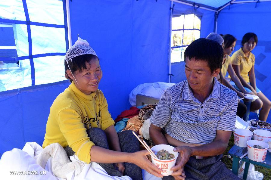 An injured woman has lunch at a temporary medical center organized by the 2nd Renmin Hospital of Jinggu County, southwest China&apos;s Yunnan Province, Oct. 8, 2014. One person died and 324 others were injured after a 6.6-magnitude quake jolted Yunnan Province Tuesday night, according to local government. Injured villagers have been sent for medical treatme