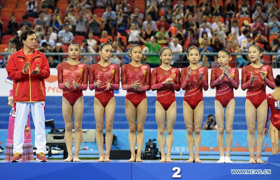 Chinese gymnasts pose on the podium during the awarding ceremony of the women&apos;s team final of the 45th Gymnastics World Championships in Nanning, capital of south China&apos;s Guangxi Zhuang Autonomous Region, Oct. 8, 2014. China won the silver medal with a total of 172.587 points.