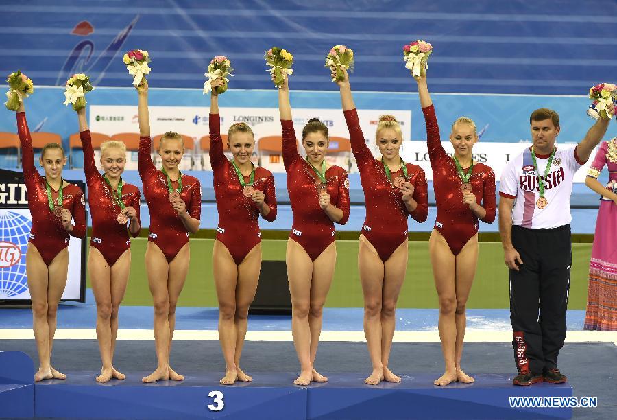 Russian gymnasts pose on the podium during the awarding ceremony of the women&apos;s team final of the 45th Gymnastics World Championships in Nanning, capital of south China&apos;s Guangxi Zhuang Autonomous Region, Oct. 8, 2014. Russia won the bronze medal with a total of 171.462 points. 