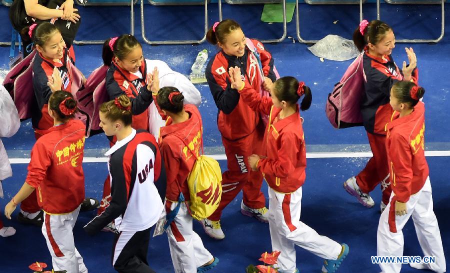 Japanese team (back) congratulate Chinese team after the women&apos;s team final of the 45th Gymnastics World Championships in Nanning, capital of south China&apos;s Guangxi Zhuang Autonomous Region, Oct. 8, 2014. Chinese team won the silver medal with a total of 172.587 points.