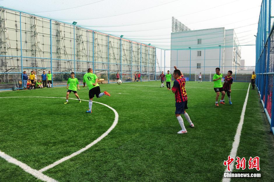 Photo taken shows people playing football at a 'football field in the air' built on the roof of a hall in Fuyang, E China’s Anhui Province on October 12, 2014. Recently, the first 2,000-square meter 'football field in the air' in Fuyang appeared at the roof of a 20-meter-high building, attracting people’s attention. (Photo by Wang Biao)