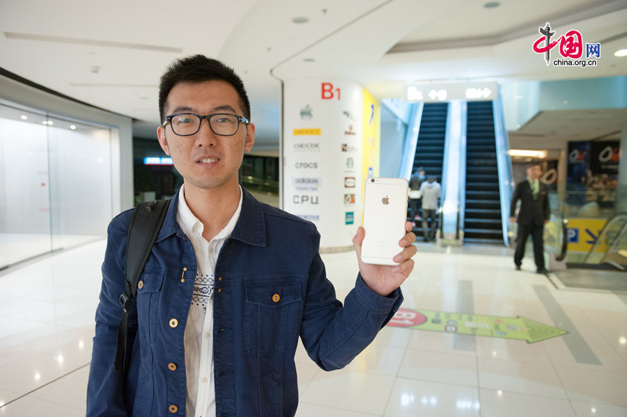 A iPhone enthusiast shows his new iPhone 6 Plus 128 GB at Apple&apos;s Wangfujing Store in downtown Beijing, on Oct. 17, 2014, the date of iPhone 6 and iPhone 6 Plus debut on the Chinese mainland. [Photo by Chen Boyuan / China.org.cn]