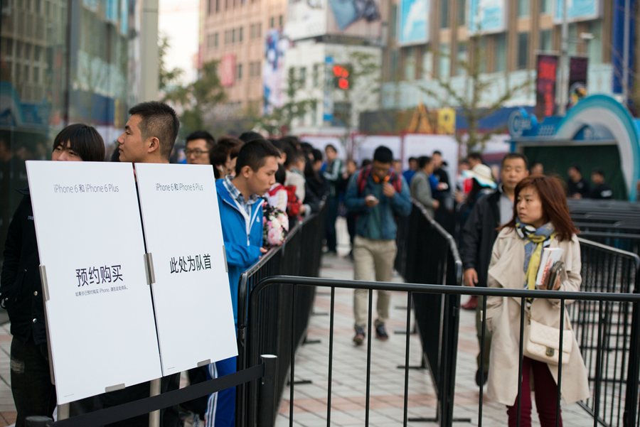 Customers to buy the latest iPhone 6 and iPhone 6 Plus queue up outside Apple&apos;s Wangfujing Store in downtown Beijing on the morning of Oct. 17, 2014, the day when the two new phones are launched in the Chinese mainland. [Photo by Chen Boyuan / China.org.cn]