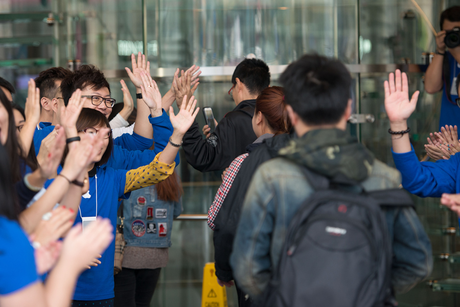 Staff members at Apple&apos;s Wangfujing Store welcome its first batch of customers of iPhone 6 and iPhone 6 Plus on the morning of Oct. 17, the date when the two phones are launched in the Chinese mainland. [Photo by Chen Boyuan / China.org.cn]