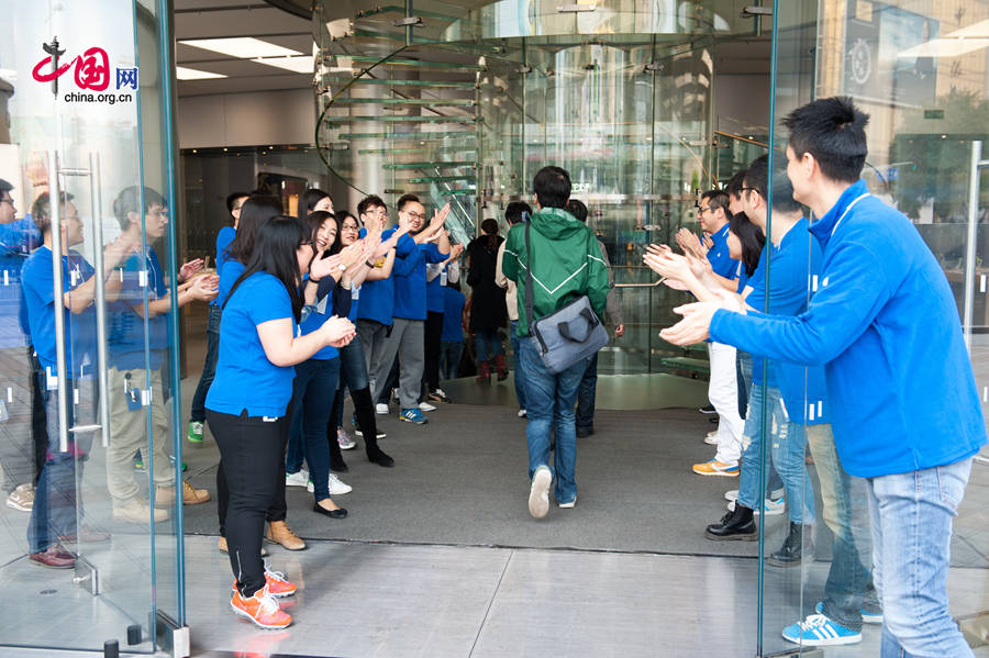 Staff members at Apple&apos;s Wangfujing Store welcome its first batch of customers of iPhone 6 and iPhone 6 Plus on the morning of Oct. 17, the date when the two phones are launched in the Chinese mainland. [Photo by Chen Boyuan / China.org.cn]