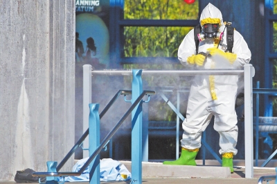10月18日，在美国达拉斯的一个车站，一名身着隔离服的工作人员正在喷洒消毒药水。当日，一名女性在达拉斯的一个车站病倒，病情症状疑似感染埃博拉病毒。[新华社]