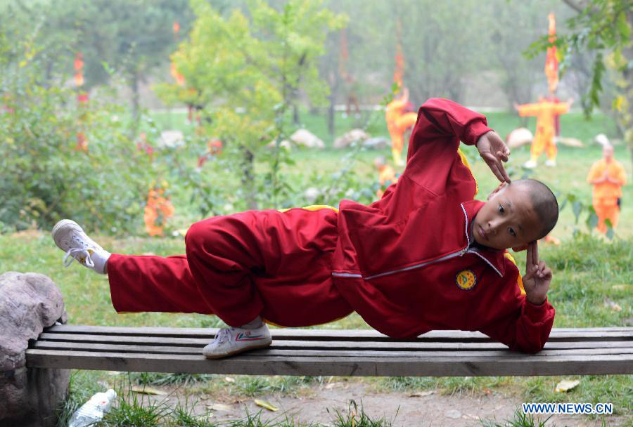 A student of a kungfu school shows kungfu during the welcoming ceremony of the 10th Zhengzhou International Shaolin Wushu Festival in Dengfeng, central China's Henan Province, Oct. 19, 2014. More than 1,800 kungfu practitioners from 63 countries and regions will participate in the three-day festival, opened on Sunday. [Photo: Xinhu a/Zhu Xiang]