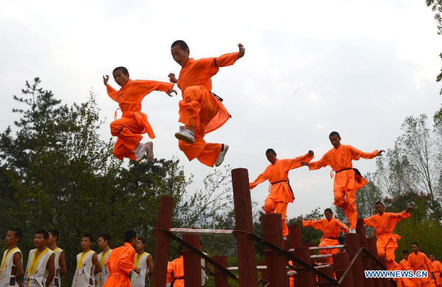 Students of a kungfu school show kungfu during the welcoming ceremony of the 10th Zhengzhou International Shaolin Wushu Festival in Dengfeng, central China's Henan Province, Oct. 19, 2014. More than 1,800 kungfu practitioners from 63 countries and regions will participate in the three-day festival, opened on Sunday. [Photo: Xinhua/Zhu Xiang]