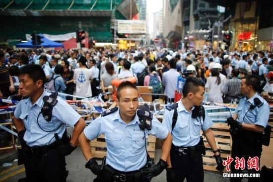 10月23日下午，香港“占领中环”非法集会者在旺角阻挡市民清除路障，引起混乱，警察在现场维持秩序。“占领中环”非法集会已进入第26日，香港市民已愤怒不已。[中新社 盛佳鹏 摄]