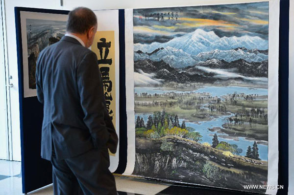 A man visits a Chinese art exhibition at the UN headquarters in New York Oct. 27, 2014. The Chinese art exhibition opened on Monday to present natural sceneries in China, with the 'preserve environment, cherish homeland' theme. [Xinhua]