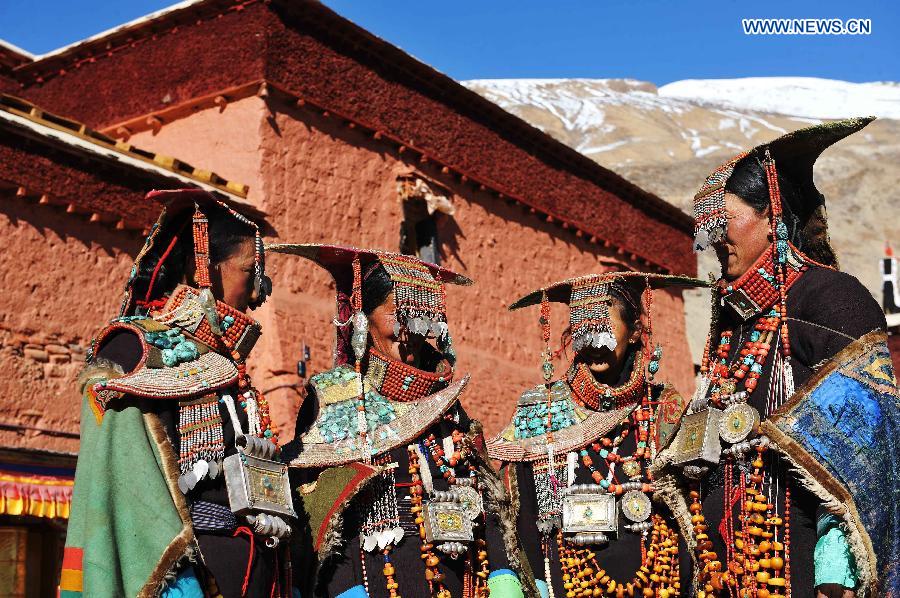 Women present Burang costumes at Kegya Village in Burang County of Nagri Prefecture, southwest China's Tibet Autonomous Region, Oct. 23, 2014. Burang costume, which has a history of more than 1,000 years, is famous for its luxurious accessories. Hundreds of pieces of beeswax, numerous pearls and kallaties, bunchy red corals and delicate silver and gold decorations compose of priceless suite. Seven households at Kegya Village have preserved seven suits of Burang costumes handed down by ancestors. [Xinhua]