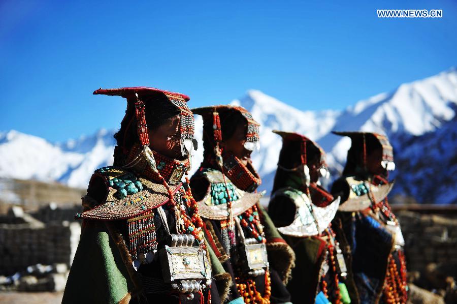 Women present Burang costumes at Kegya Village in Burang County of Nagri Prefecture, southwest China's Tibet Autonomous Region, Oct. 23, 2014. Burang costume, which has a history of more than 1,000 years, is famous for its luxurious accessories. Hundreds of pieces of beeswax, numerous pearls and kallaties, bunchy red corals and delicate silver and gold decorations compose of priceless suite. Seven households at Kegya Village have preserved seven suits of Burang costumes handed down by ancestors. [Xinhua]