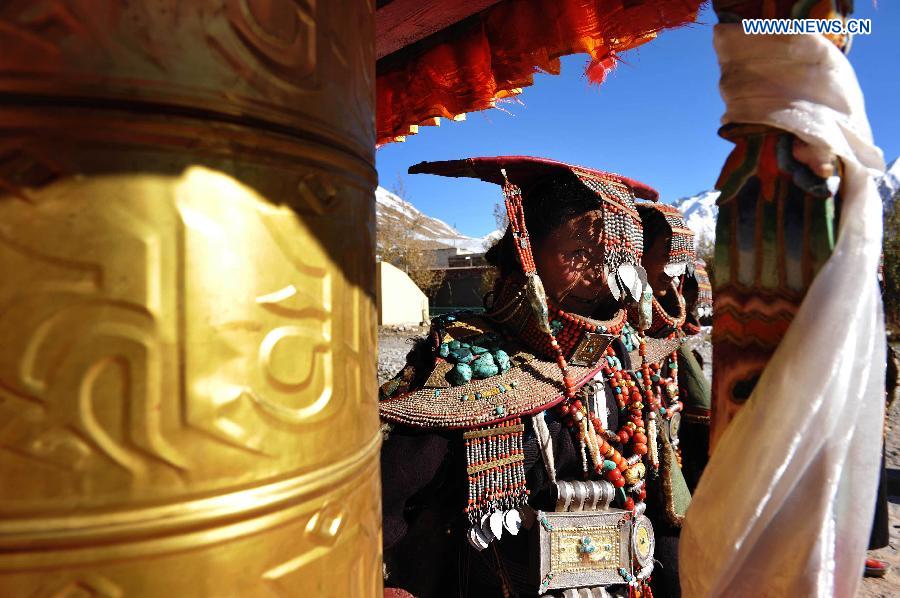 Women wearing Burang costumes walk at Kegya Village in Burang County of Nagri Prefecture, southwest China's Tibet Autonomous Region, Oct. 23, 2014.