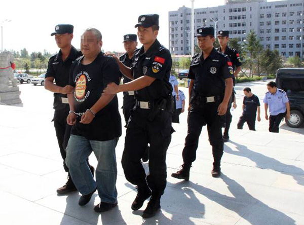 A suspect surnamed Duan is repatriated on Aug 30. [Photo/China Daily]