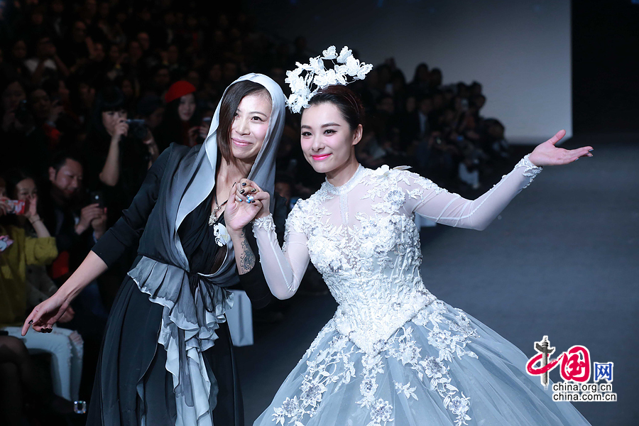 Former Olympic gymnastics champion Liu Xuan presents a wedding gown designed by Peng Jing during China Fashion Week in Beijing, capital of China, Oct. 26, 2014. [China.org.cn]