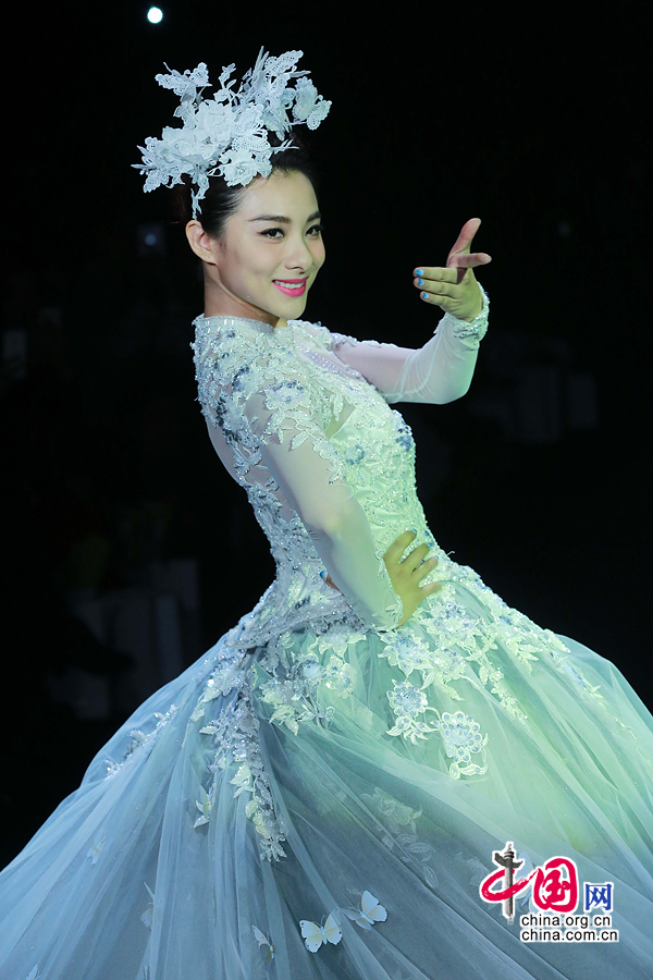 Former Olympic gymnastics champion Liu Xuan presents a wedding gown designed by Peng Jing during China Fashion Week in Beijing, capital of China, Oct. 26, 2014. [China.org.cn]