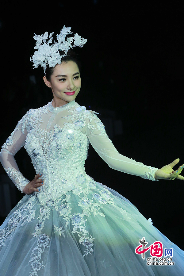 Former Olympic gymnastics champion Liu Xuan presents a wedding gown designed by Peng Jing during China Fashion Week in Beijing, capital of China, Oct. 26, 2014. [China.org.cn]