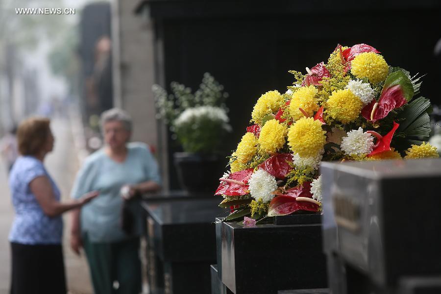 Flowers are placed on a grave during the commemoration of the Day of the Dead, at the Araca municipal cementery in Sao Paulo, Brazil, on Nov. 2, 2014. [Photo/Xinhua]
