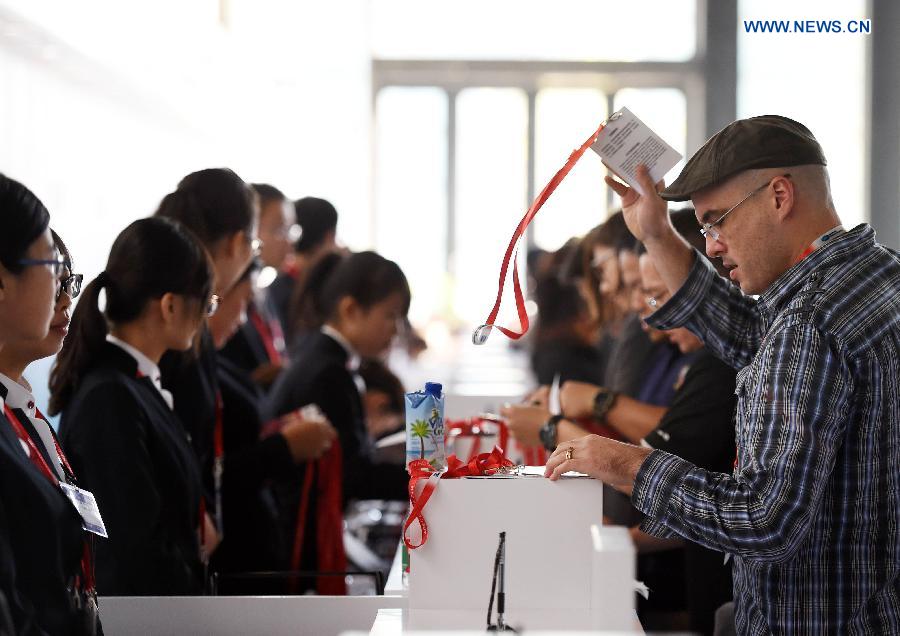 A participant receives his badge at the registration center for the 2014 APEC Economic Leaders' Week in Beijing, China, Nov. 3, 2014. The registration center for the APEC meeting in Beijing was officially opened on Monday, providing reception service running from 8:00 a.m. to 6:00 p.m. [Photo/Xinhua]