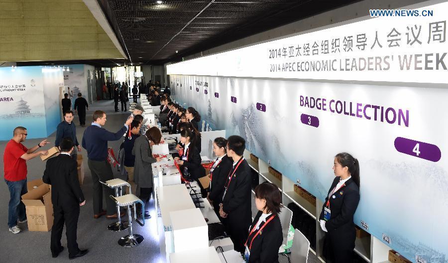 Participants receive their badges at the registration center for the 2014 APEC Economic Leaders' Week in Beijing, China, Nov. 3, 2014. The registration center for the APEC meeting in Beijing was officially opened on Monday, providing reception service running from 8:00 a.m. to 6:00 p.m. [Photo/Xinhua]
