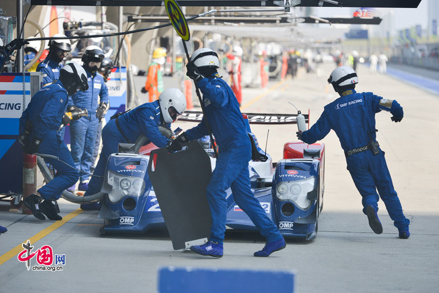 Motor racing teams that include Aston Martin, Ferrari, Porsche, Audi and Toyota compete in the Shanghai grand prix of the FIA World Endurance Championship on Sunday, Nov.2, 2014. Toyota won the GTE professional award and Aston Martin, whose cars are partly powered by Hanergy solar panels, pocketed the first and second prizes of the GTE amateur award. [Photo by Chen Boyuan / China.org.cn]