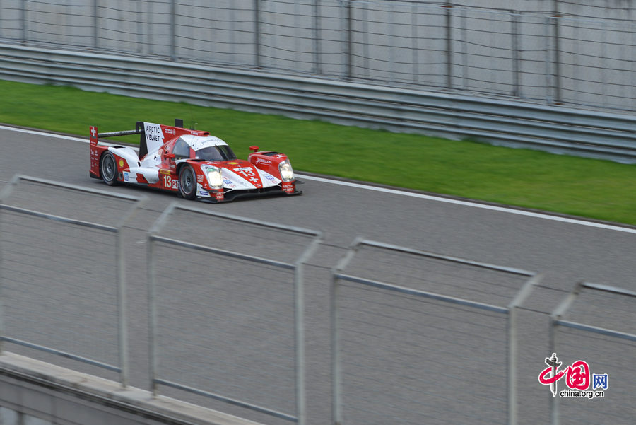 Motor racing teams that include Aston Martin, Ferrari, Porsche, Audi and Toyota compete in the Shanghai grand prix of the FIA World Endurance Championship on Sunday, Nov.2, 2014. Toyota won the GTE professional award and Aston Martin, whose cars are partly powered by Hanergy solar panels, pocketed the first and second prizes of the GTE amateur award. [Photo by Chen Boyuan / China.org.cn]