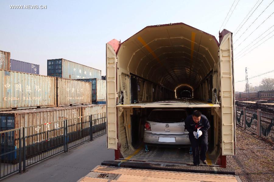 A worker loads a car onto a carriage at Dahongmen Railway Station in Beijing, capital of China, Nov. 4, 2014. Beijing Railway Bureau has opened several special train routes for self-driving tourists during the vacation of the Asia-Pacific Economic Cooperation (APEC) Economic Leaders' Week, which will be held in Beijing from Nov. 5 to 11. [Photo/Xinhua] 