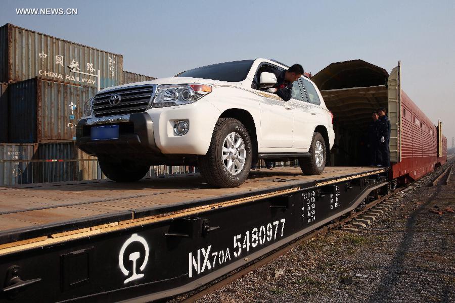 Workers load a car onto a carriage at Dahongmen Railway Station in Beijing, capital of China, Nov. 4, 2014. Beijing Railway Bureau has opened several special train routes for self-driving tourists during the vacation of the Asia-Pacific Economic Cooperation (APEC) Economic Leaders' Week, which will be held in Beijing from Nov. 5 to 11. [Photo/Xinhua]
