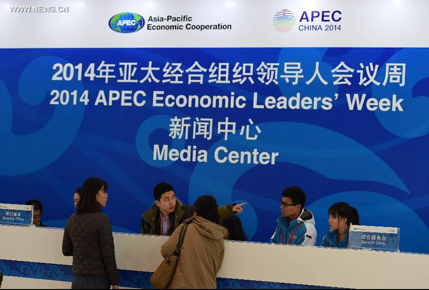 Volunteers work at an information desk in the media center for the 2014 Asia-Pacific Economic Cooperation (APEC) Economic Leaders' Week at China National Convention Center (CNCC) in Beijing, capital of China, Nov. 4, 2014. The 2014 APEC Economic Leaders' Week will be held in Beijing from Nov. 5 to 11. The media center at CNCC opened to media on Tuesday to provide all-round services to media organizations. (Xinhua/Chen Yehua) 