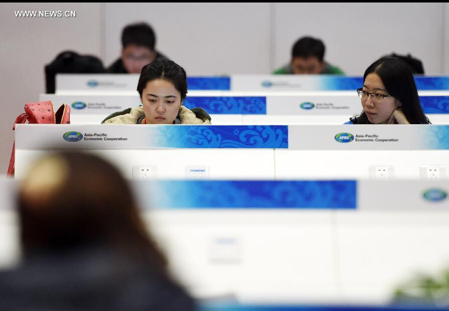 Journalists work in the media center for the 2014 Asia-Pacific Economic Cooperation (APEC) Economic Leaders' Week at China National Convention Center (CNCC) in Beijing, capital of China, Nov. 4, 2014. The 2014 APEC Economic Leaders' Week will be held in Beijing from Nov. 5 to 11. The media center at CNCC opened to media on Tuesday to provide all-round services to media organizations. (Xinhua/Chen Yehua) 