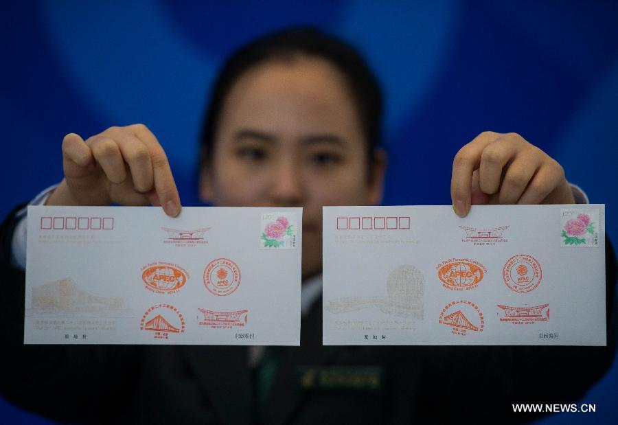 A staff member shows postmarked commemorative envelopes issued for the upcoming 22nd APEC Economic Leaders' Meeting (AELM) in Beijing, China, Nov. 5, 2014. [Photo/Xinhua] 