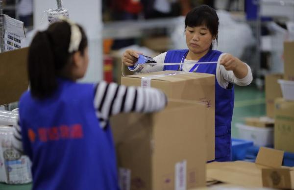 Employees work at an Alibaba Group warehouse on the outskirts of Hangzhou, Zhejiang province Oct 30, 2014. [Photo / Agencies]