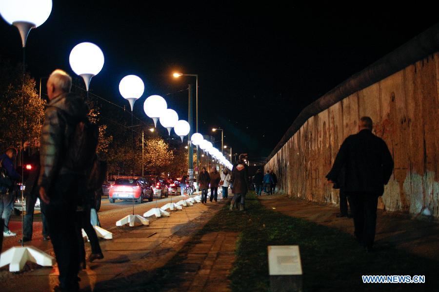 Visitors view a light installation of balloons along the course of former Berlin Wall at a Berlin Wall memorial site in Berlin, Germany, on Nov. 8, 2014. 