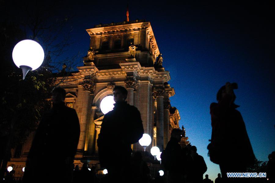 Visitors view a light installation of balloons along the course of former Berlin Wall at a Berlin Wall memorial site in Berlin, Germany, on Nov. 8, 2014. 
