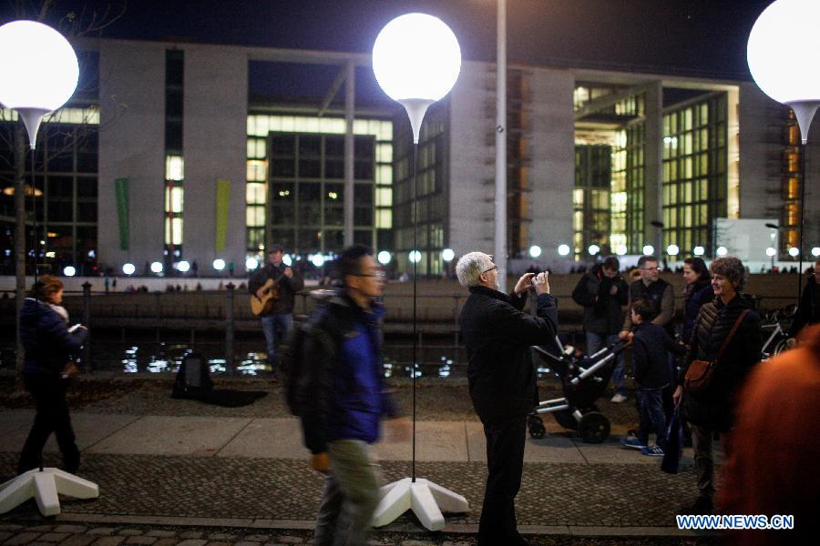 Visitors view a light installation of balloons along the course of former Berlin Wall at a Berlin Wall memorial site in Berlin, Germany, on Nov. 8, 2014.