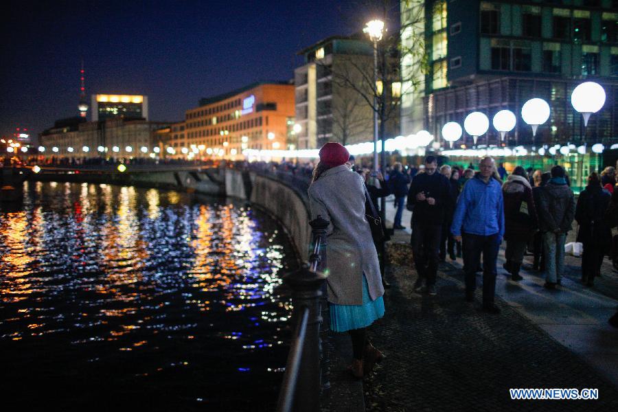 Visitors view a light installation of balloons along the course of former Berlin Wall at a Berlin Wall memorial site in Berlin, Germany, on Nov. 8, 2014. 