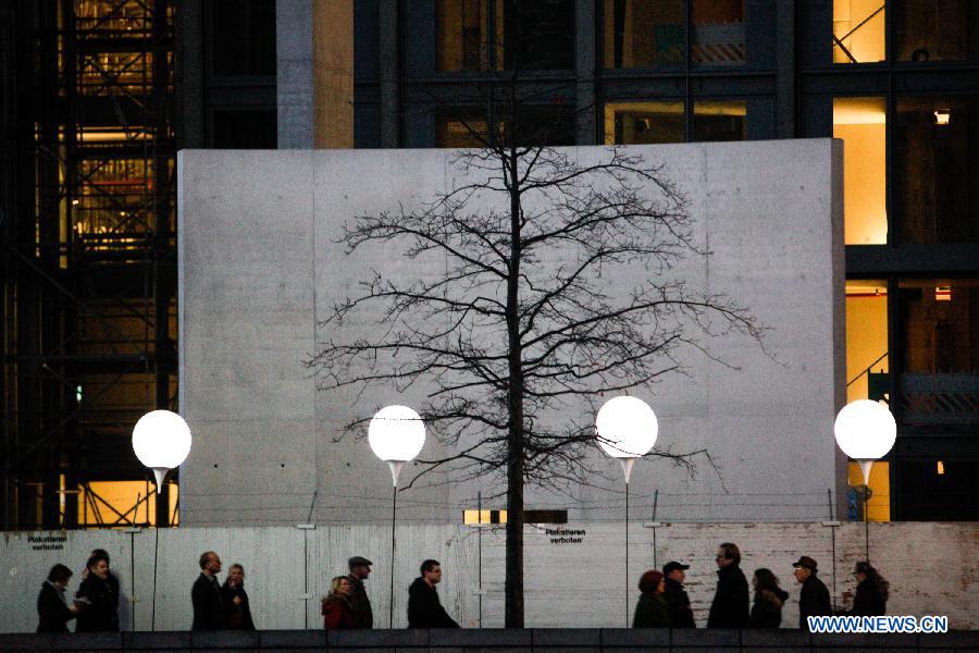 Visitors view a light installation of balloons along the course of former Berlin Wall at a Berlin Wall memorial site in Berlin, Germany, on Nov. 8, 2014. 