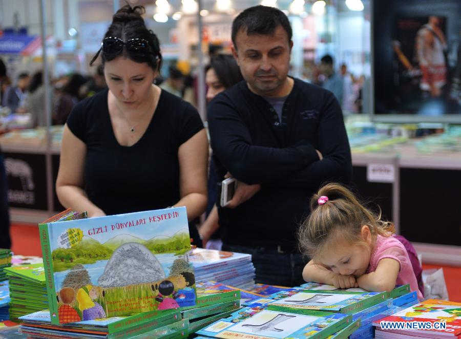 A girl is attracted by a children&apos;s book in the 33rd International Istanbul Book Fair in Istanbul, Turkey on Nov. 8, 2014