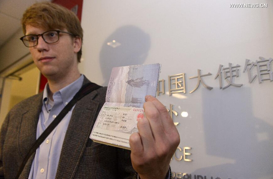Edmund Thomas Downie shows his visa to the press after becoming the first American citizen to be issued a ten-year visa at the Visa Department of the Chinese Embassy to the United States in Washington D.C., Nov. 12, 2014. 