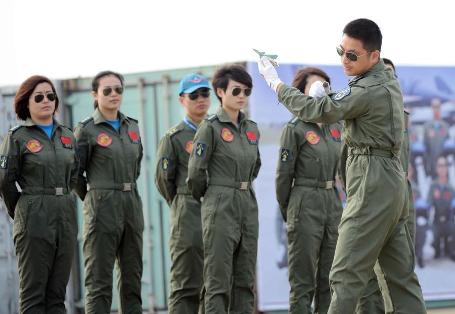 Members of China's Bayi Aerobatic Team watch a senior member explain a maneuver with a model during training exercises for the 10th China International Aviation and Aerospace Exhibition in Zhuhai, South China's Guangdong province on Nov 11, 2014. [Photo/Xinhua] 