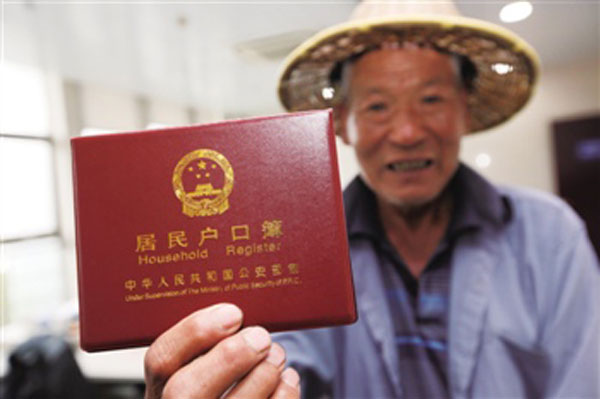 An old man holds his hukou book – household register before the camera. Henan province issued a guideline on November 12 to unify the hukou system. [Photo: Baidu.com]
