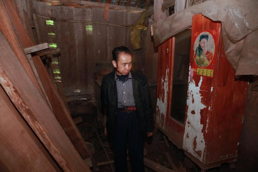Wang Benyu walks in his dilapidated home after spending 18 years behind bars, in Xinqiao town of Suining city, Southwest China's Sichuan province on April 6, 2014. 