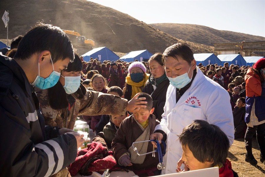 Medical staff and rescue workers check students from a primary school in Kangding yesterday.