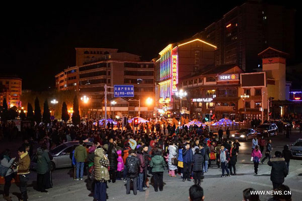 Residents stand on the road to avoid the earthquake in Kangding County, southwest China's Sichuan Province, Nov. 25, 2014. A 5.8-magnitude earthquake struck Kangding County, Ganzi Tibetan Autonomous Prefecture of southwest China's Sichuan Province, at 11:19 p.m. Tuesday, the China Earthquake Networks Center said. [Xinhua]