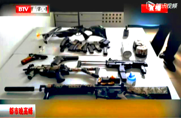 The scree grab from Beijing TV news shows imitation guns police found in the man's place.