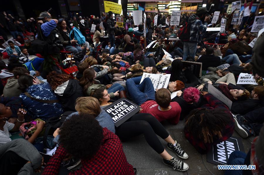 People take part in a protest in New York, the United States, on Dec. 1, 2014. Demonstrations continue over a grand jury's decision last week not to charge police officer Darren Wilson who fatally shot unarmed 18-year-old Michael Brown in Ferguson, Missouri.[Photo/Xinhua] 